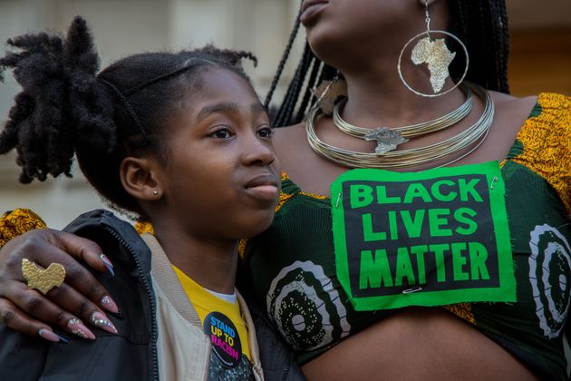 A woman wearing a BLM t-shirt embraces her child outside Hackney Town Hall during the Child Q rally. 