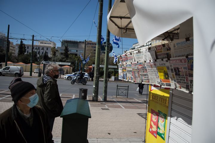People are looking newspapers on a kiosk in the center of Athens, Greece on March 24, 2022. (Photo by Nikolas Kokovlis/NurPhoto via Getty Images)