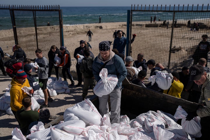 Volunteers load a vehicle with sandbags to defend the city, in Odesa, southern Ukraine, on March 23, 2022. The Black Sea port is mining its beaches and rushing to defend itself from a Mariupol-style fate. (AP Photo/Petros Giannakouris, File)