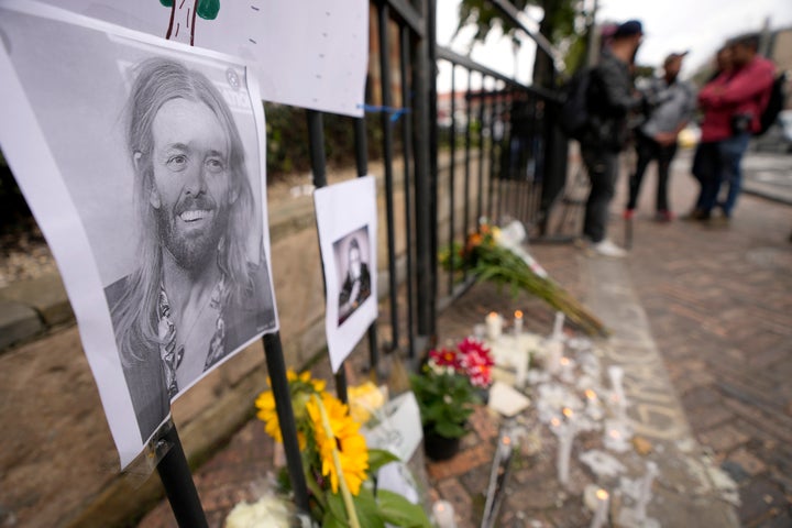 Seguidores de la banda Foo Fighters depositan flores junto a la fotografía de Taylor Hawkins.