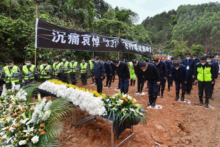 Officials and search and rescue workers bow and pause for a three-minute moment of silence for the 132 people killed on Sunday.