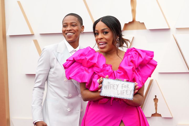 Nash shows off her clutch — a gift from Betts — on the Oscars red carpet.
