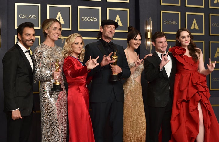 Eugenio Derbez, from left, Sian Heder, Marlee Matlin, Troy Kotsur, Emilia Jones, Daniel Durant, and Amy Forsyth, winners of the award for Best Picture for "CODA," pose in the press room while signing "I love you" at the Oscars on Sunday, March 27.