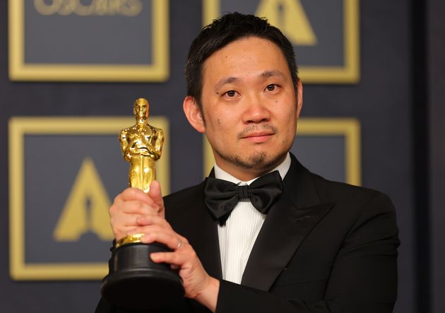 国際長編映画賞を受賞し、オスカー像を掲げる濱口竜介監督