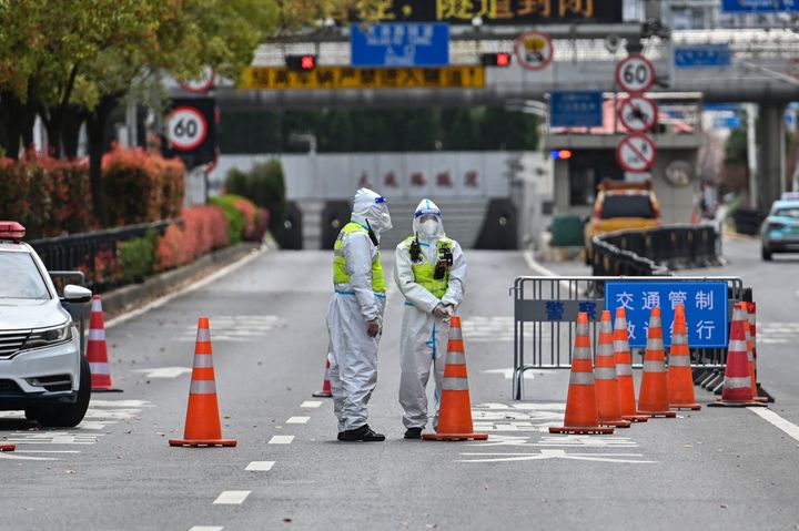 Police officers wearing protective gear control access to a tunnel in the direction of Shanghai's Pudong district on Monday. (Photo by HECTOR RETAMAL/AFP via Getty Images)