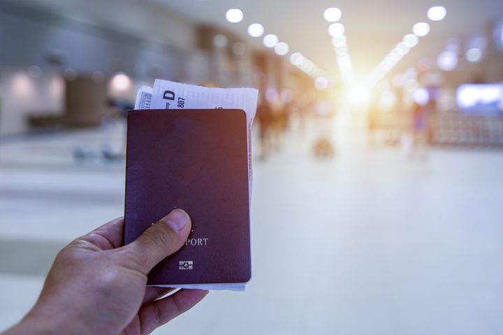 Closeup of man hand holding passports and boarding pass at airport.