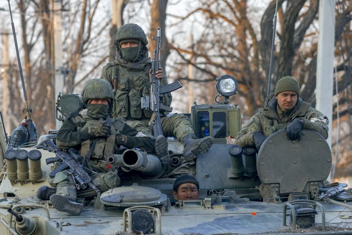 Russian soldiers are seen on a tank in Donetsk, Ukraine. Britain’s Defense Ministry says Russia plans to hire a private military contractor to fight in Ukraine after the regular Russian military suffered heavy losses.