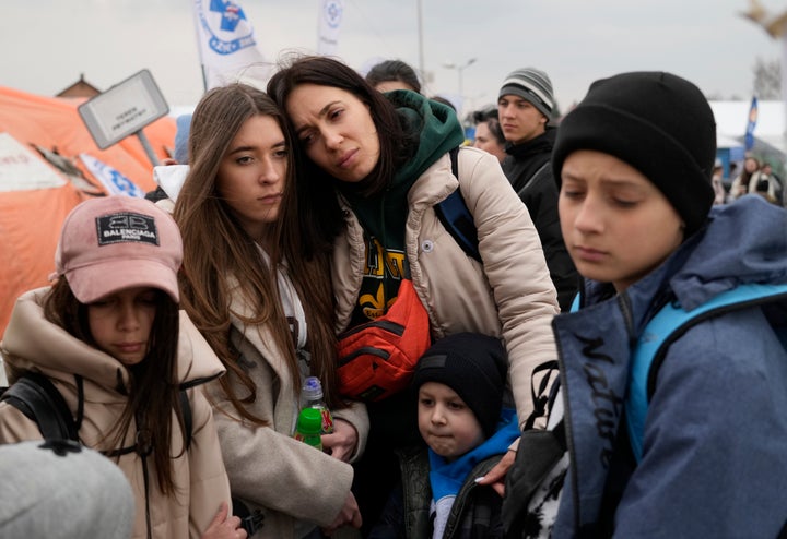 Refugees wait in a queue, after fleeing the war from neighbouring Ukraine at the border crossing in Medyka, southeastern Poland, on March 29, 2022.