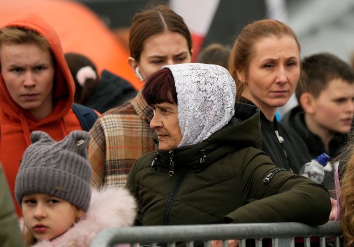 Refugees wait in a queue after fleeing the war from neighbouring Ukraine, at the border crossing in Medyka, southeastern Poland, on March 29, 2022. 