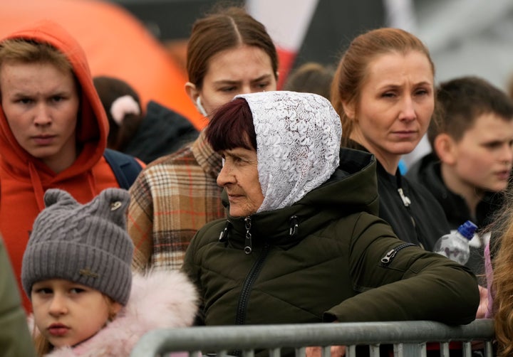 Refugees wait in a queue after fleeing the war from neighbouring Ukraine, at the border crossing in Medyka, southeastern Poland, on March 29, 2022.