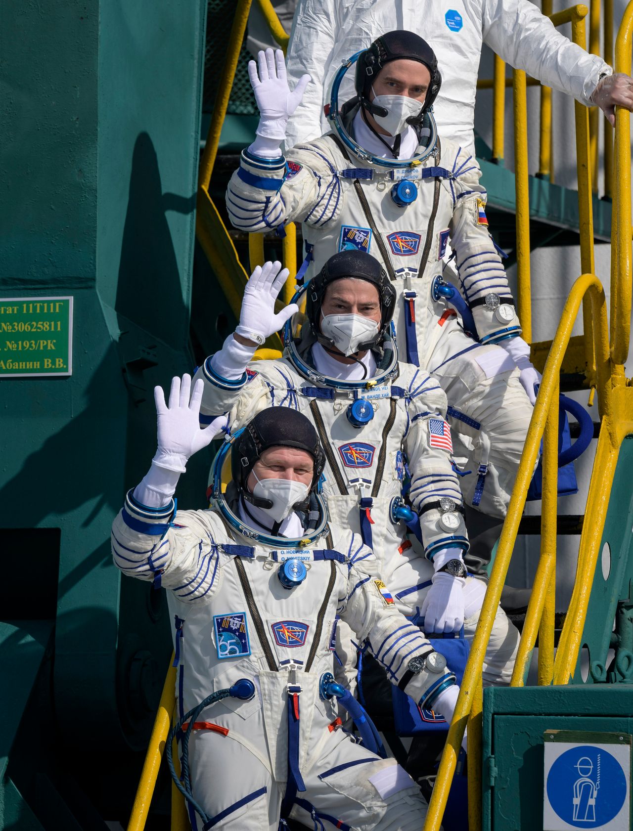 Σε αυτήν την φωτογραφία που παρέχεται από τη NASA, ο Ρώσος κοσμοναύτης Πιότρ Ντουμπρόφ, ο κορυφαίος, ο αστροναύτης της NASA Mαρκ Βάντε Χάι και ο Ρώσος κοσμοναύτης Oλεγκ Noβίτσκι αποχαιρετούν τον κόσμο πριν επιβιβαστούν στο διαστημόπλοιο Soyuz MS-18 για εκτόξευση, Παρασκευή 9 Απριλίου 2021, στο Κοσμοδρόμιο Μπαϊκονούρ στο Καζακστάν.
