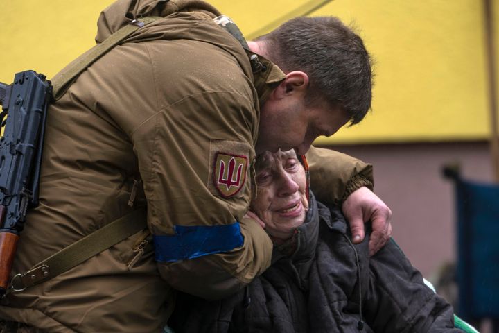 A soldier comforts Larysa Kolesnyk, 82, after she was evacuated from Irpin, on the outskirts of Kyiv, Ukraine, Wednesday, March 30, 2022. (AP Photo/Rodrigo Abd)