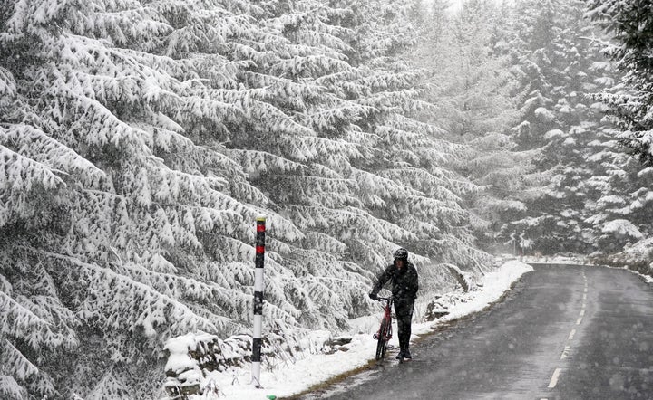 A person trying to cycle in the Pennines on Wednesday March 30, 2022.