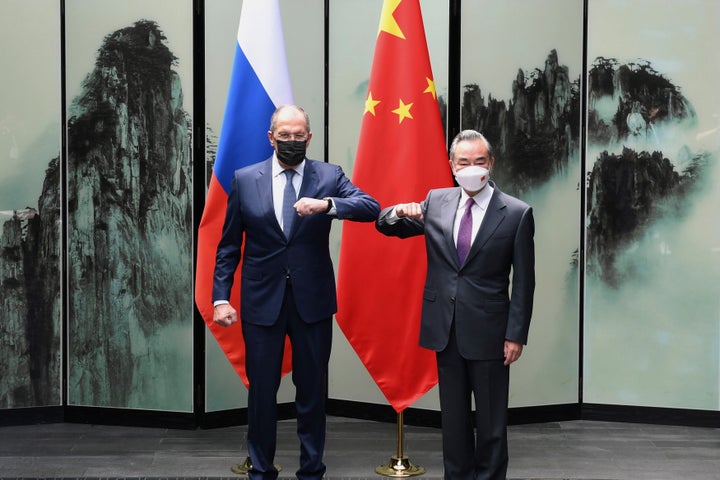 Chinese Foreign Minister Wang Yi poses for photos with Russian Foreign Minister Sergei Lavrov in Tunxi, in the province of Anhui in eastern China, on Wednesday.