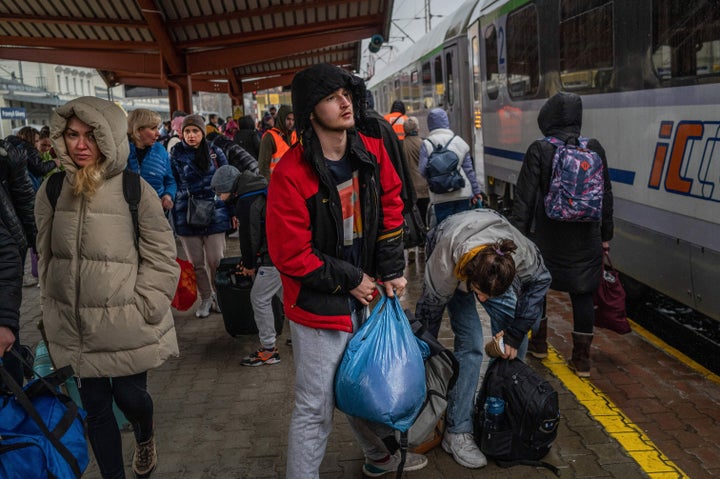 Ukrainian refugees board a train en route to Warsaw March 31, 2022 at the railway station in Przemysl near the Polish-Ukrainian border.