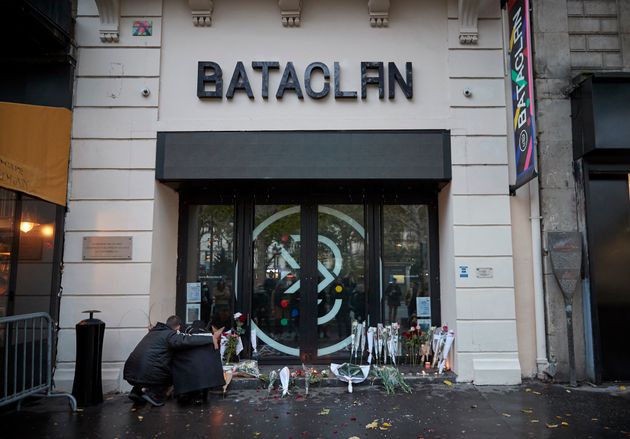 Des passants déposent des fleurs devant la salle de concert du Bataclan à Paris, où...