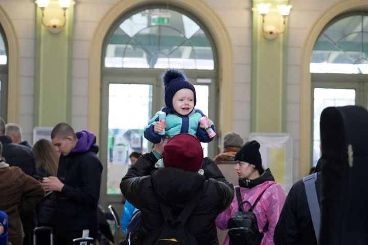 A refugee holds a child after fleeing the war from neighbouring Ukraine at a railway station in Przemysl, Poland, on April 1, 2022. 