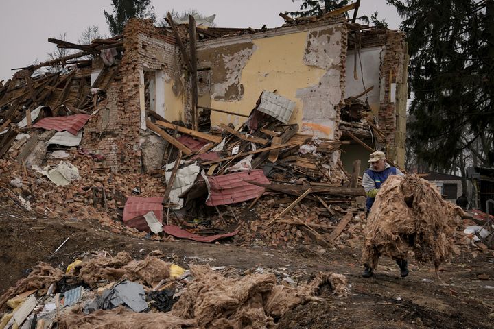 A man carries debris from buildings destroyed during fighting between Russian and Ukrainian forces outside Kyiv, Ukraine, on April 1, 2022.