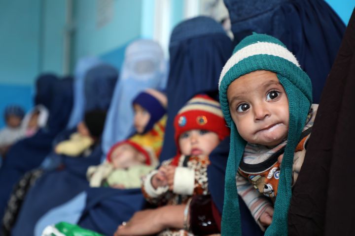 Afghan children are seen with their mothers on Jan. 16 in Kabul, Afghanistan, where rates of malnutrition are soaring.