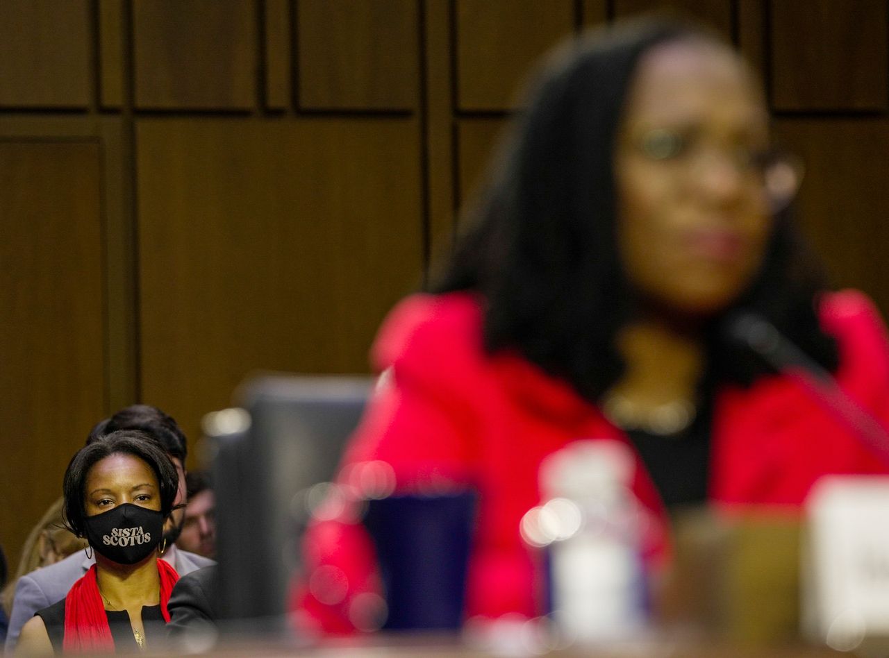 A woman in a "Sista SCOTUS" mask watches Jackson's confirmation hearing on March 22.
