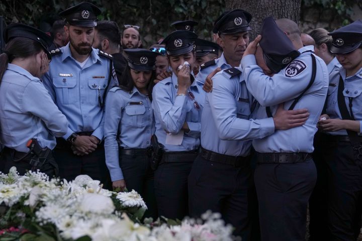 Israeli police officers weep for their slain colleague: one of five killed by a Palestinian gunman in a crowded city in central Israel late Tuesday, the second mass shooting rampage this week. (AP Photo/Ariel Schalit)