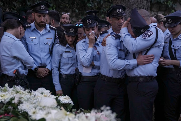 Israeli police officers weep for their slain colleague: one of five killed by a Palestinian gunman in a crowded city in central Israel late Tuesday, the second mass shooting rampage this week. (AP Photo/Ariel Schalit)