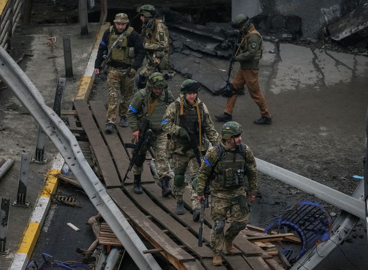 Ukrainian servicemen walk on a destroyed bridge as Russia's invasion of Ukraine continues, in the town of Irpin outside Kyiv, Ukraine April 1, 2022. REUTERS/Gleb Garanich