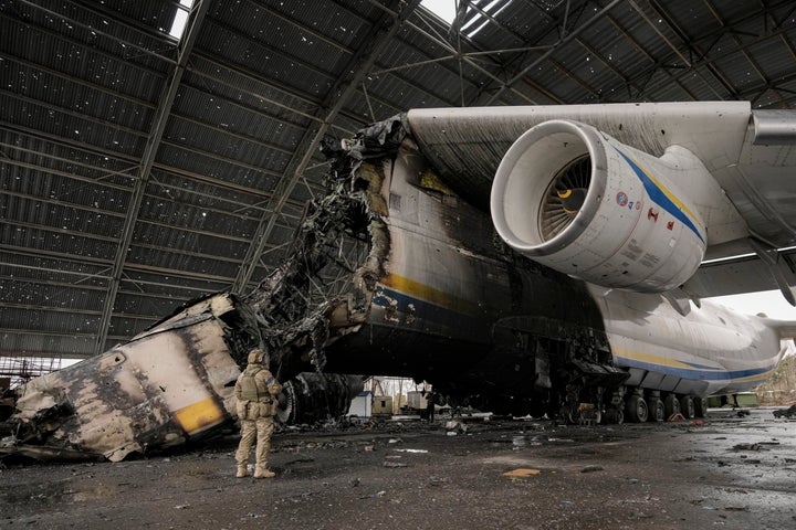 2022年4月2日、アントノフ空港で、ロシア軍とウクライナ軍との戦闘中に破壊された「An-225ムリーヤ」のそばを歩くウクライナの軍人(AP Photo/Vadim Ghirda)