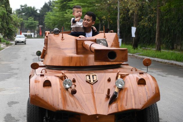 息子と一緒に木製の戦車に乗り込むダオさん (Photo by NHAC NGUYEN/AFP via Getty Images)