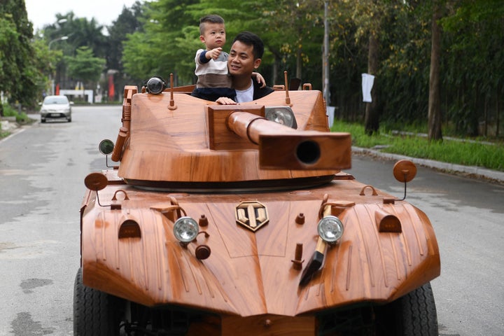 息子と一緒に木製の戦車に乗り込むダオさん (Photo by NHAC NGUYEN/AFP via Getty Images)