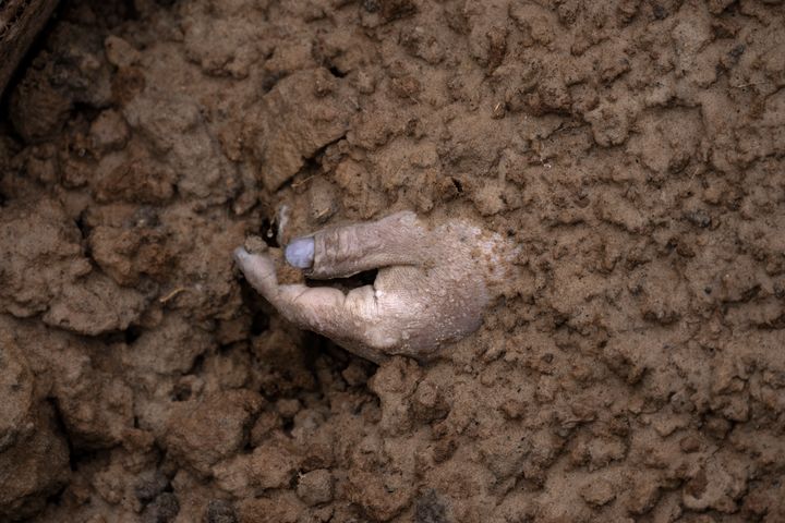 The hand of a corpse buried with other bodies is seen in a mass grave in Bucha, on the outskirts of kyiv, Ukraine, on April 3.