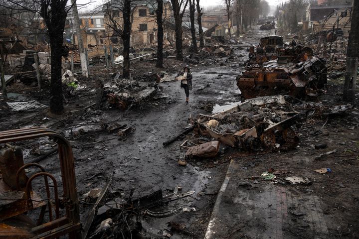 A woman walks amid destroyed Russian tanks in Bucha, in the outskirts of Kyiv, Ukraine, on April 3, 2022.