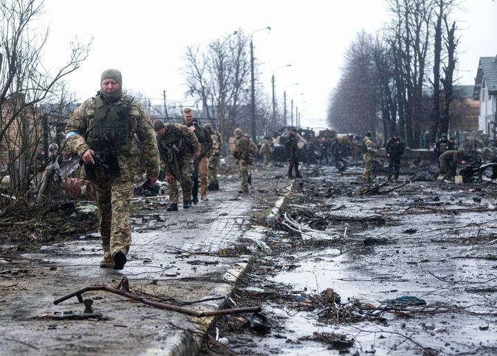 Ukrainian soldiers inspect the wreckage of a destroyed Russian armoured column on the road in Bucha, a suburb north of Kyiv. 