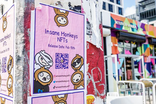 A poster advertising Insane Monkeys NFTs with QR code in Miami, Florida.