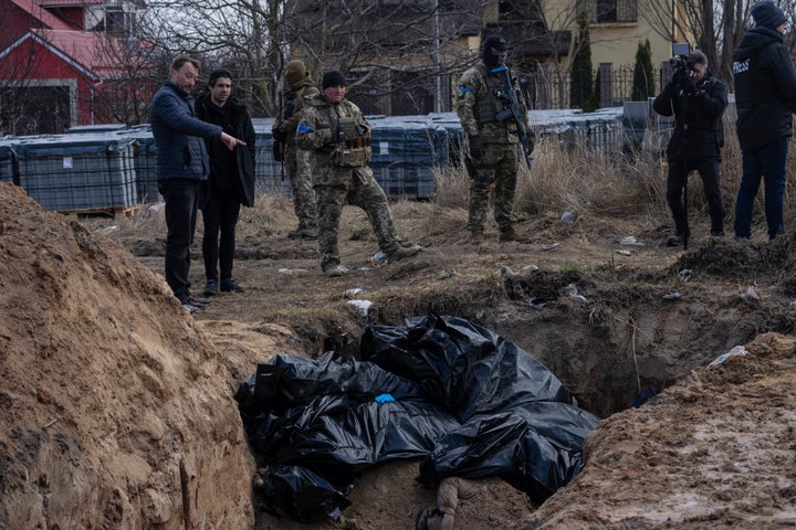 Zelenskyy To Deal with UN Amid Outrage Over Civilian Deaths 16 People stand next to a mass grave in Bucha, on the outskirts of Kyiv, Ukraine, on April 4, 2022.