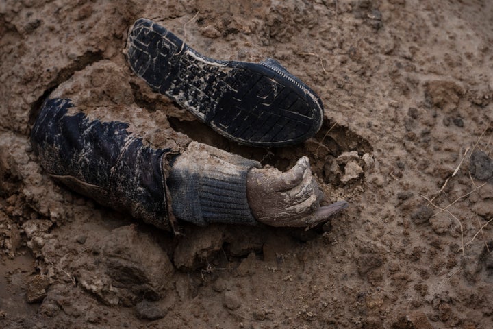 The hand of a corpse emerges from a mass grave in Bucha, on the outskirts of Kyiv on Monday. Associated Press journalists have seen dozens of bodies dumped there.