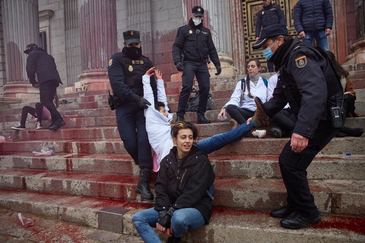 Activistas de 'Rebelión científica' arrojan pintura roja en la fachada del Congreso.