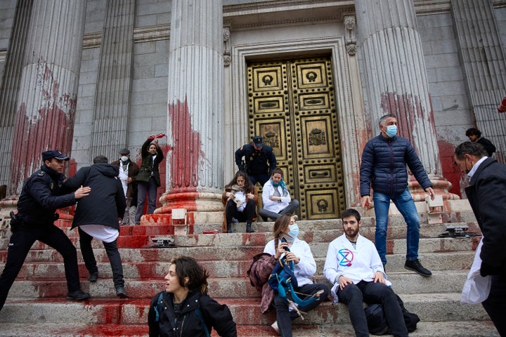 Activistas de 'Rebelión científica' arrojan pintura roja en la fachada del Congreso.