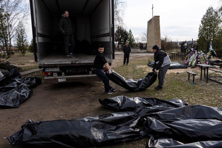 Cemetery workers load the corpses of civilians killed in Bucha, to be transported to the morgue, on the outskirts of Kyiv, Ukraine, on April 6, 2022. 