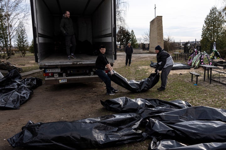 Cemetery workers load the corpses of civilians killed in Bucha, to be transported to the morgue, on the outskirts of Kyiv, Ukraine, on April 6, 2022.