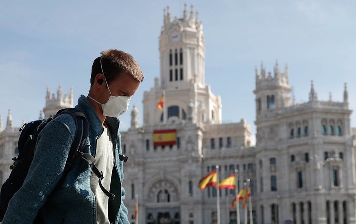 Un hombre camina con mascarilla frente al Ayuntamiento de Madrid