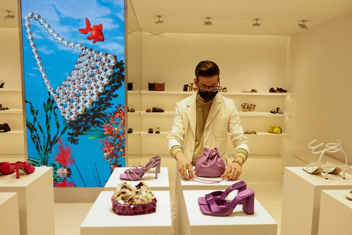 Un dependiente coloca unos accesorios en la zona de calzado y bolsos.