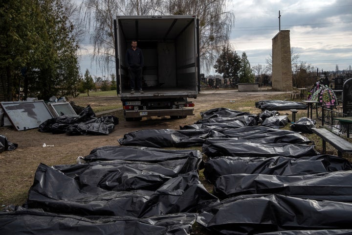 A cemetery worker waits in a truck before colleagues start to load the corpses of civilians killed in Bucha before transporting them to the morgue, on the outskirts of Kyiv, on April 6.