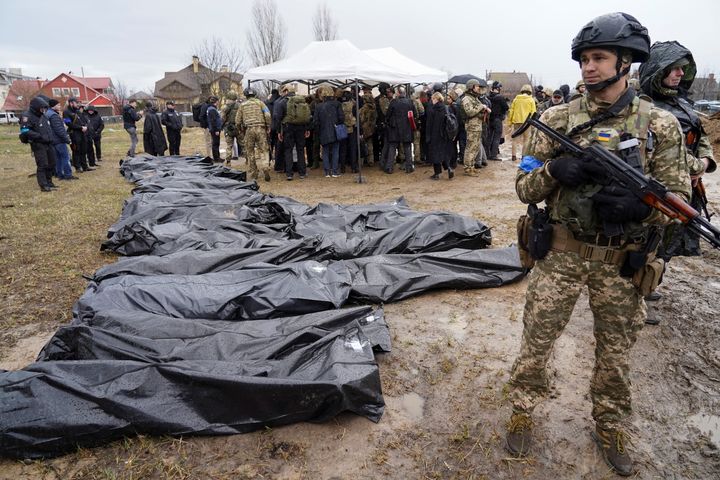 Ουκρανοί στρατιώτες δίπλα σε πτώματα που ανασύρθηκαν από ομαδικό τάφο, κατά τη διάρκεια επίσκεψης της προέδρου της Ευρωπαϊκής Επιτροπής Ουρσουλα φον ντερ Λάιεν, του ύπατου εκπροσώπου της Ευρωπαϊκής Ένωσης για θέματα εξωτερικής πολιτικής και πολιτικής ασφαλείας Ζοσέπ Μπορέλ και του πρωθυπουργού της Ουκρανίας Ντένις Σμίχαλ στην Μπούτσα.