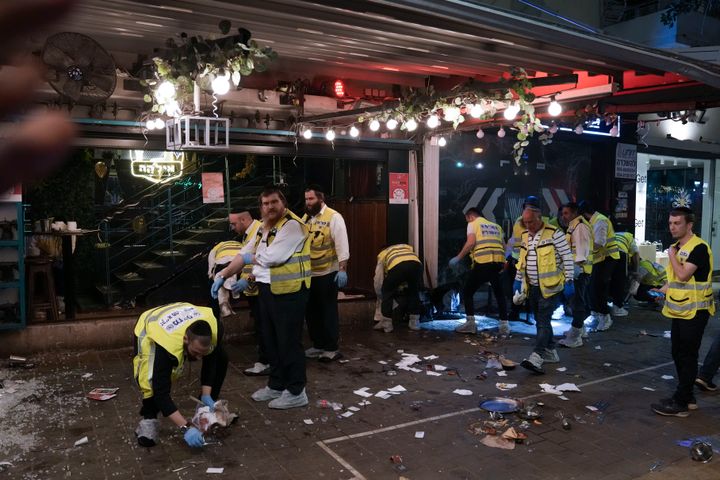 Members of Israeli Zaka Rescue and Recovery team clean blood from the site of a shooting attack In Tel Aviv, Israel, on April 7, 2022. 