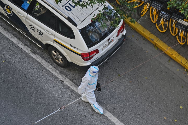 防護服に身を包んだ警察官 4月8日 上海市(Photo by HECTOR RETAMAL/AFP via Getty Images)