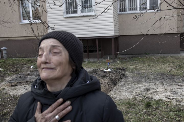 BUCHA, KYIV PROVINCE, UKRAINE, APRIL 04: Tanya Nedashkivska, 57, grieves next to the tomb of her husband buried on the backyard of her house in Bucha, Ukraine, April 4th, 2022. Tanya alleges her husband was tortured and executed by Russian soldiers in the town of Bucha, on the outskirts of Kyiv, after the Ukrainian army secured the area following the withdrawal of the Russian army from the Kyiv region on previous days. (Photo by Narciso Contreras/Anadolu Agency via Getty Images)