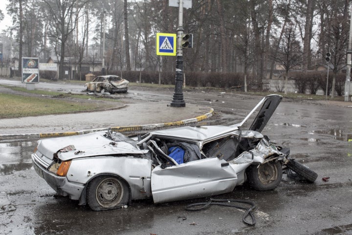 BUCHA, KYIV PROVINCE, UKRAINE, APRIL 03: (EDITOR'S NOTE: Image depicts death) The body of a man lays inside a car ran over by a Russian tank in Bucha district on the outskirts of Kyiv, after the Ukrainian army secured the area following the withdrawal of the Russian army from the Kyiv region on previous days, Bucha, Ukraine on April 03, 2022. (Photo by Narciso Contreras/Anadolu Agency via Getty Images)