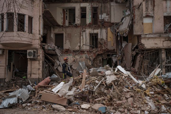 Firefighters clear the debris and search for bodies under the rubble of a building after receiving reports of smell emerging from the area, hit weeks ago by a Russian attack in Kharkiv, Ukraine, Monday, April 11, 2022. (AP Photo/Felipe Dana)