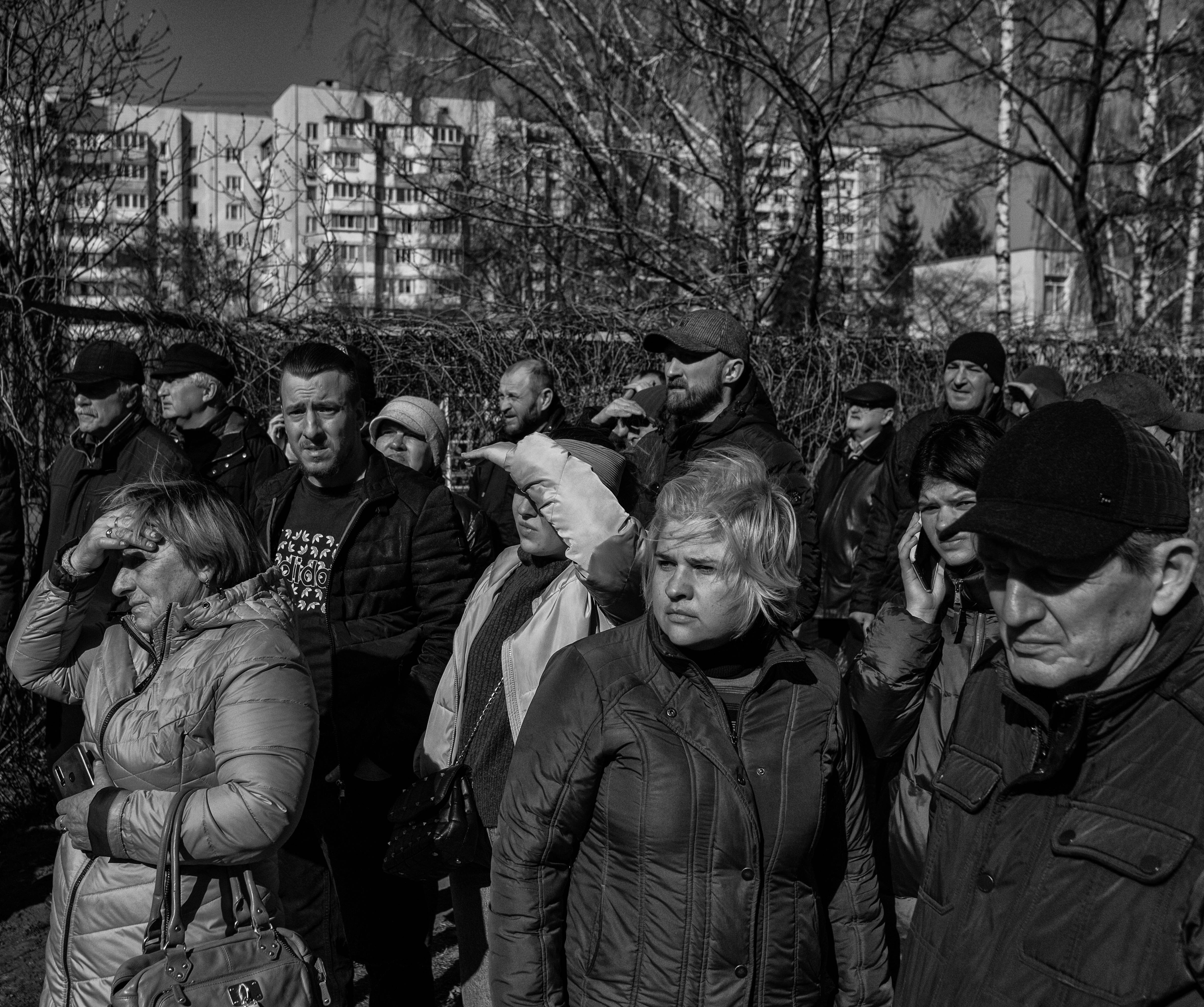 People look on after a Russian missile was shot down over apartment buildings in Bilychi, Kyiv, on Sunday, March 20.
